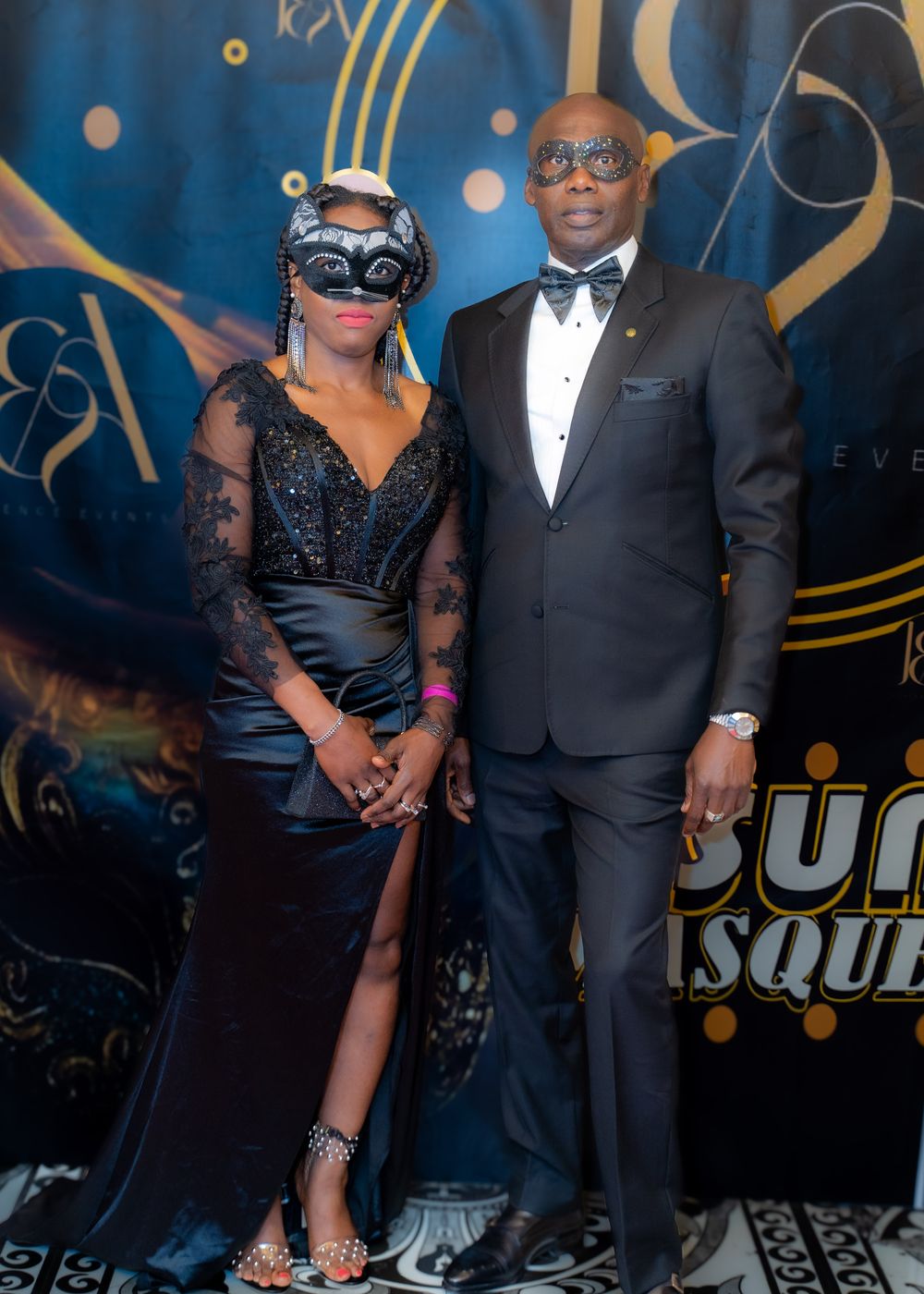 A couple in masquerade masks and black tie